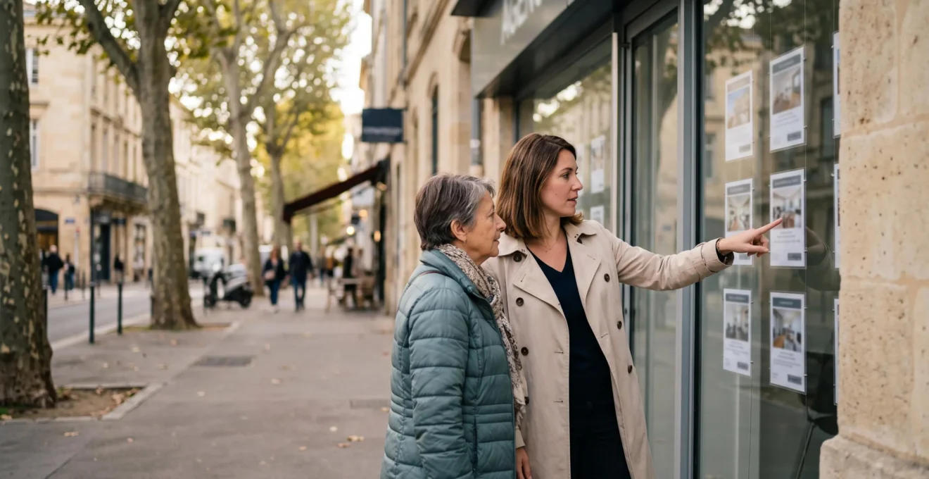 Une négociatrice immobilière explique une annonce affichée dans la vitrine d'une agence à une cliente, sur un trottoir bordelais.